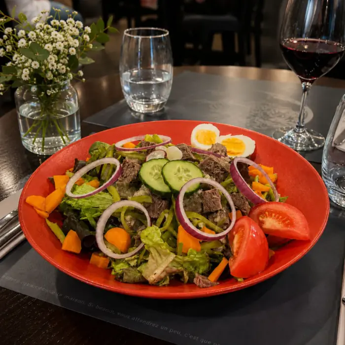 Salade gourmande retravaillée, lumière chaude, dressage soigné